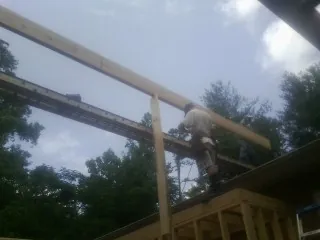 Carpenter setting a ridge beam over a new addition frame — Ice Dam Removal by Roofing Brothers in Perkinsville